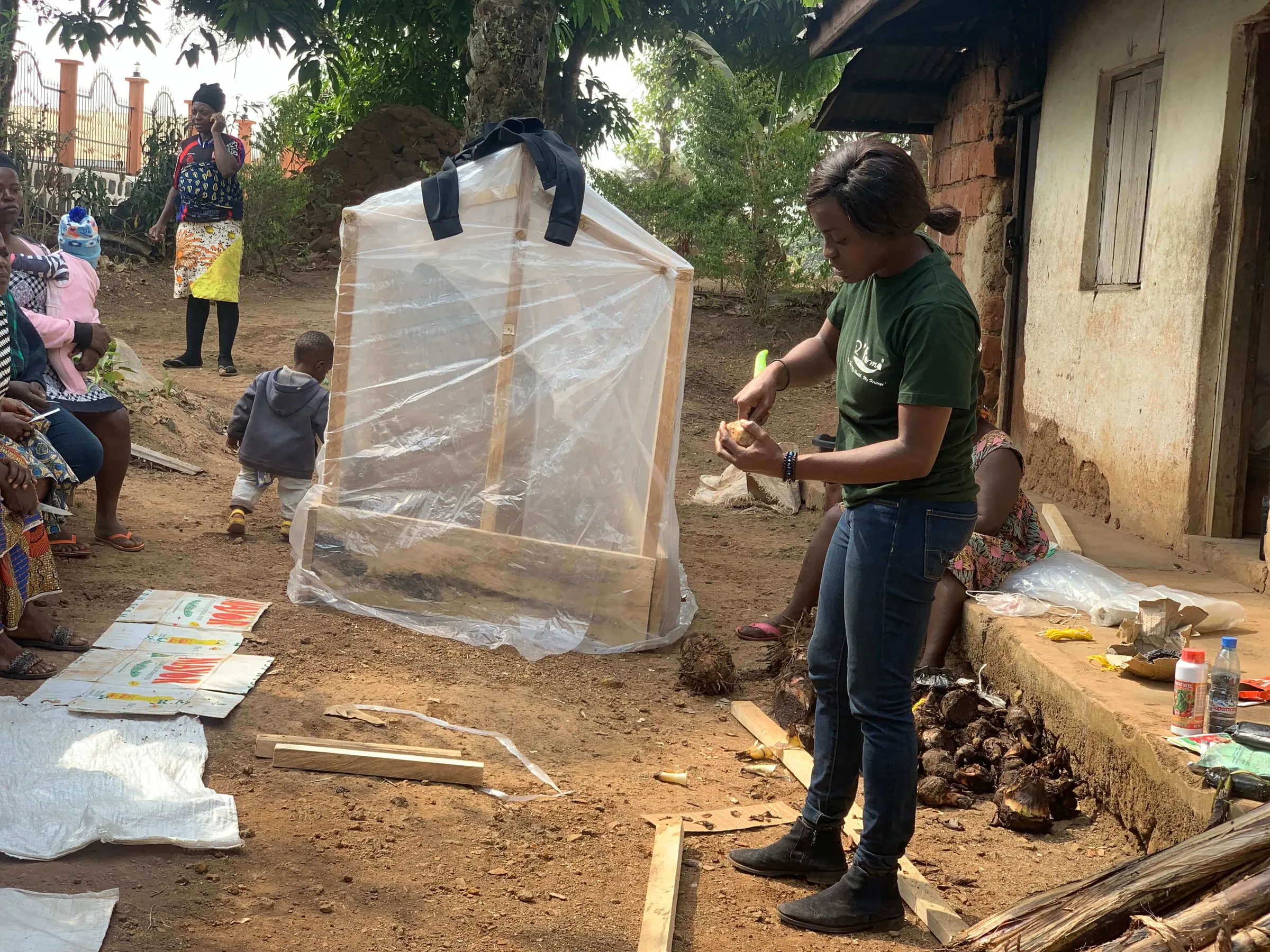 A Mumita trainer beside a small greenhouse frame covered in plastic sheeting