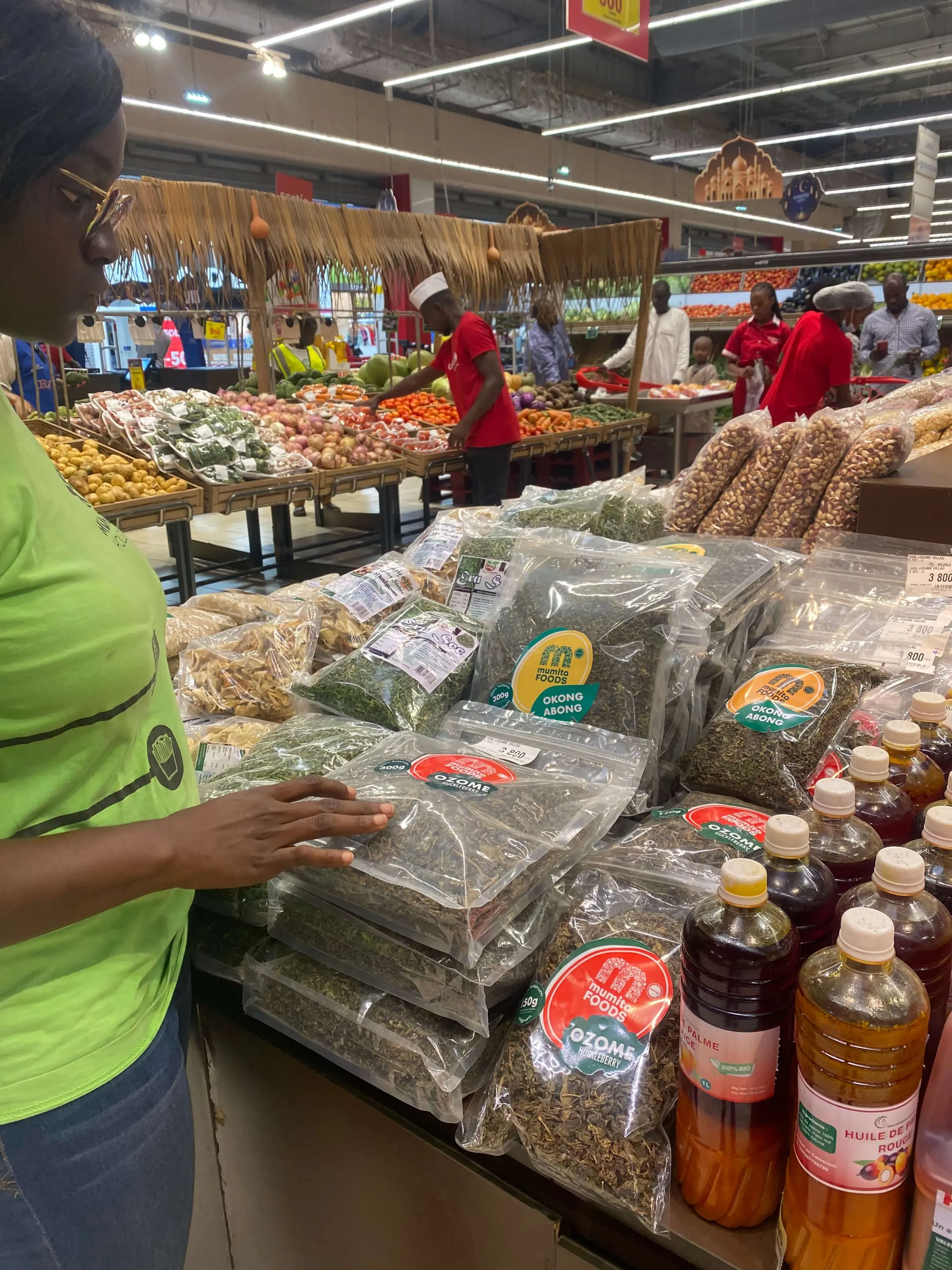 A shopper picks up a pack from a supermarket display of dried vegetables and palm oil
