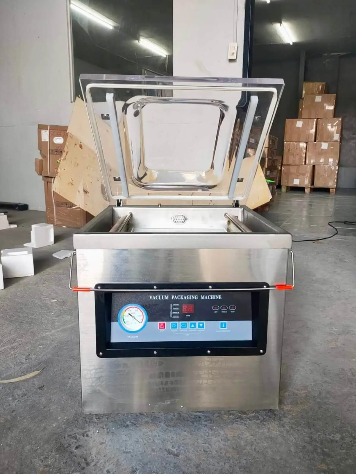 A vacuum packaging machine on a steel bench