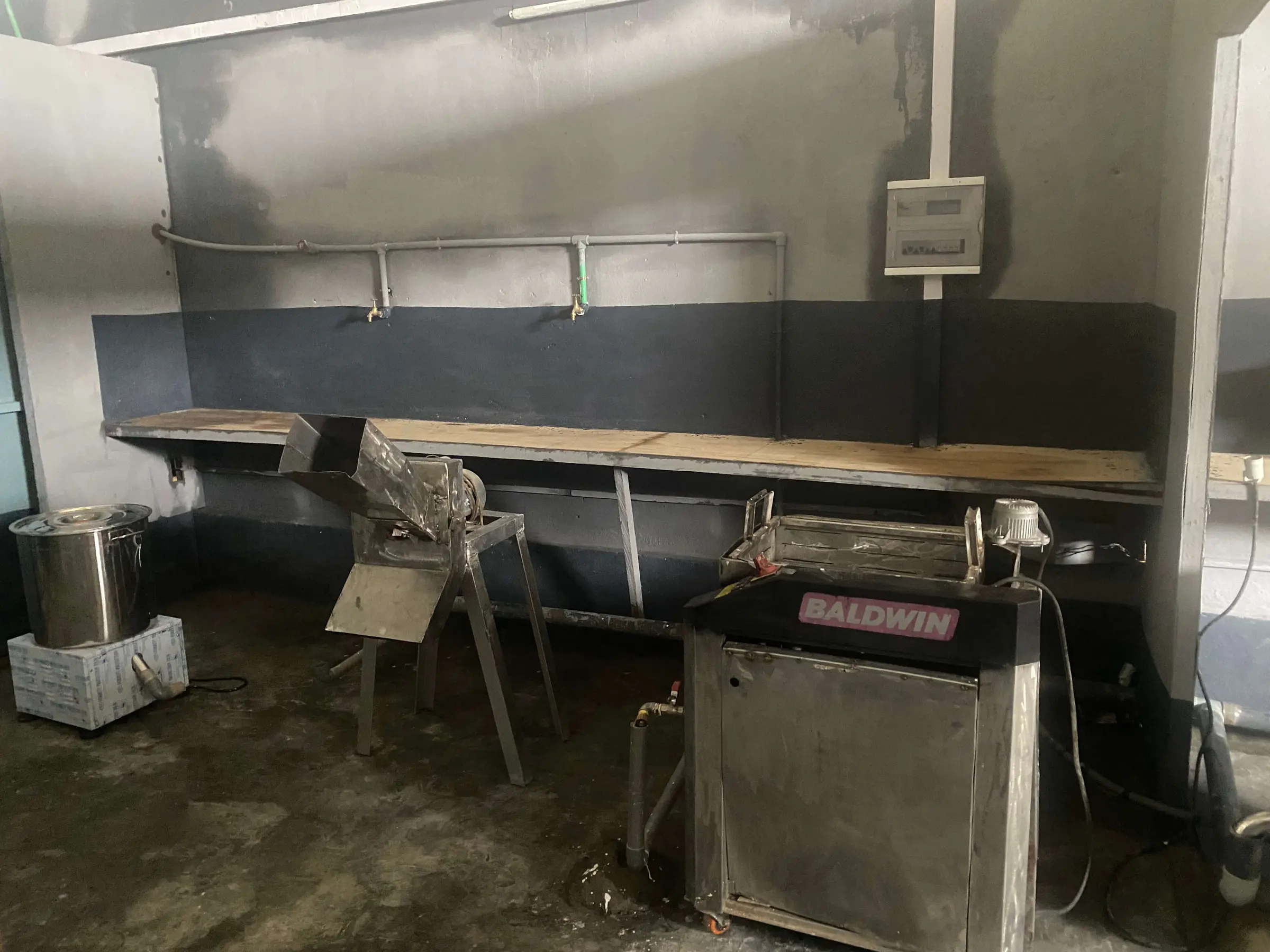 A processing room with a bench and a packing machine against the wall