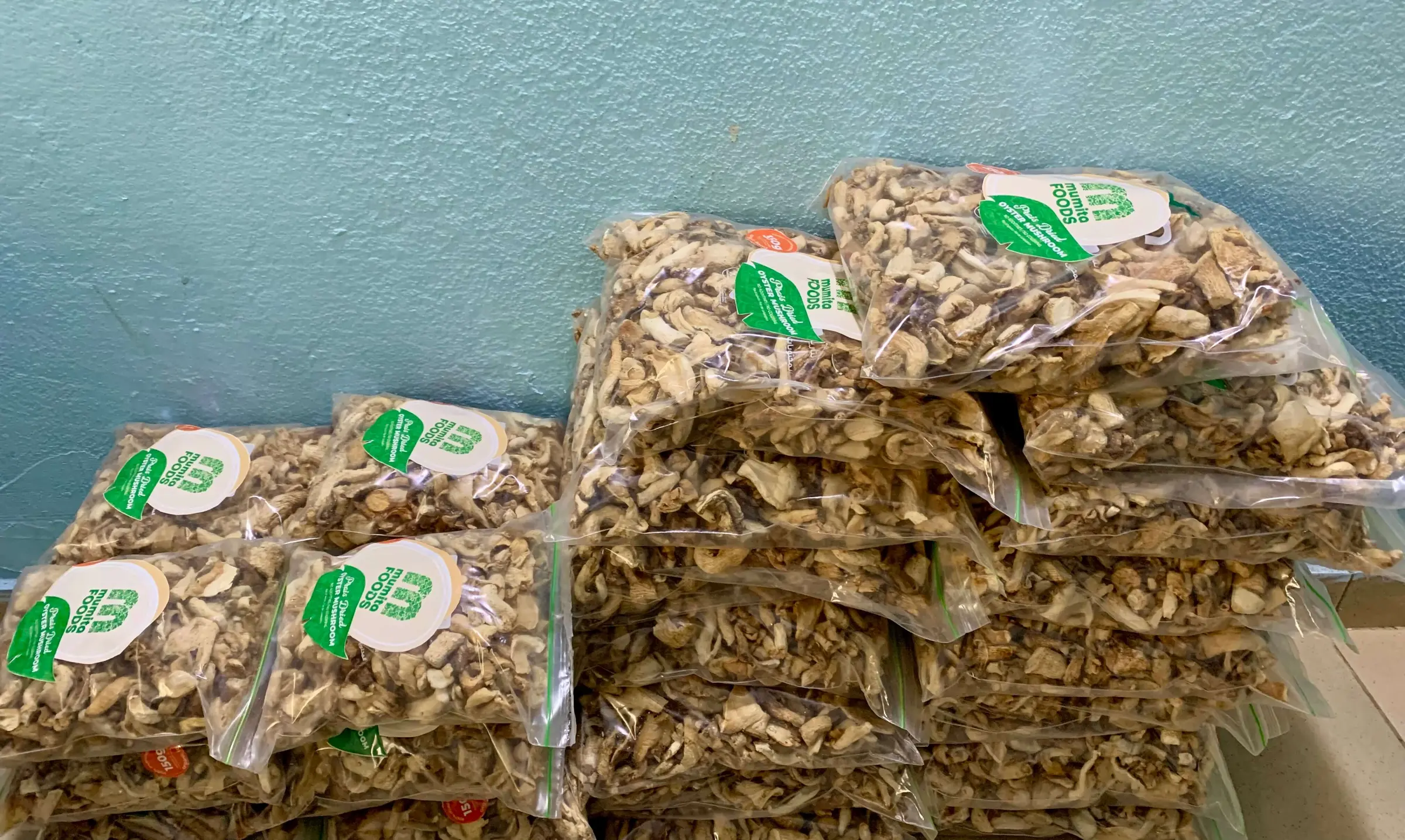 Clear bags of dried mushroom slices with Mumita Foods labels