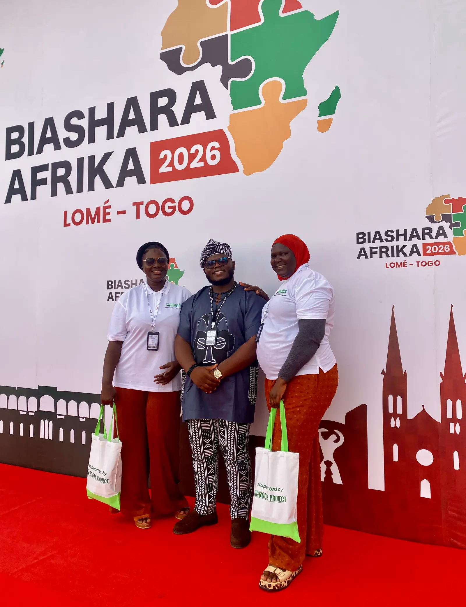 Three members of the Mumita delegation in front of the Biashara Afrika 2026 backdrop in Lomé