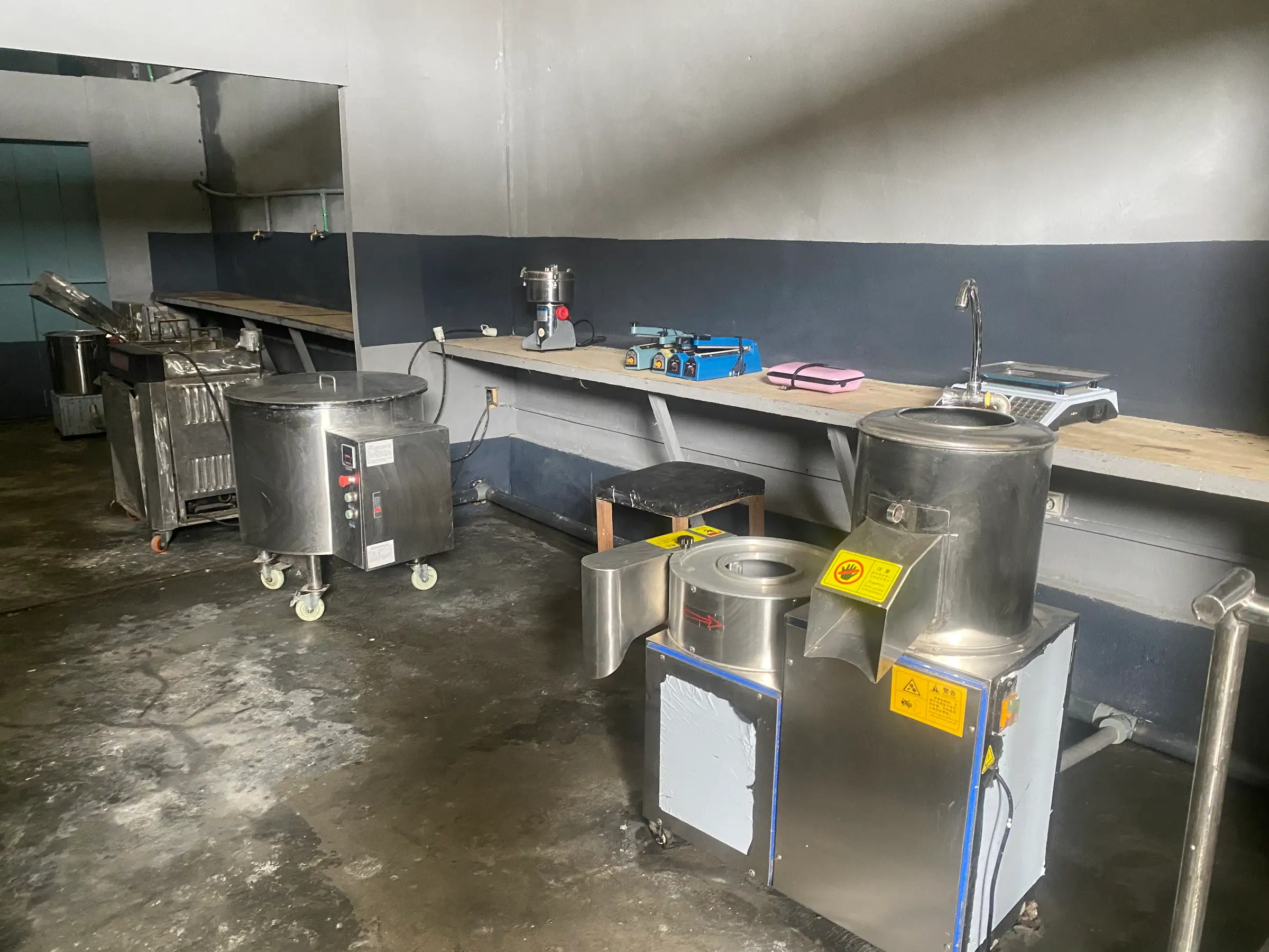 The fitted processing room: a stainless steel peeler, cooking vat, mill and benches