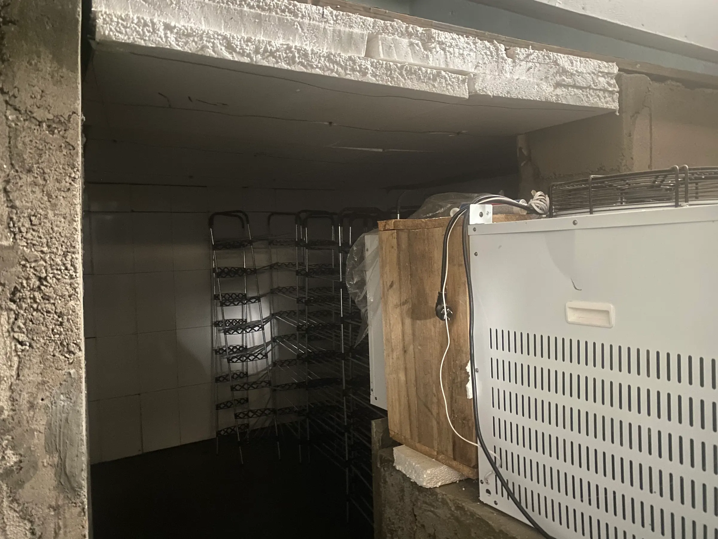 A refrigeration condensing unit mounted beside an insulated room