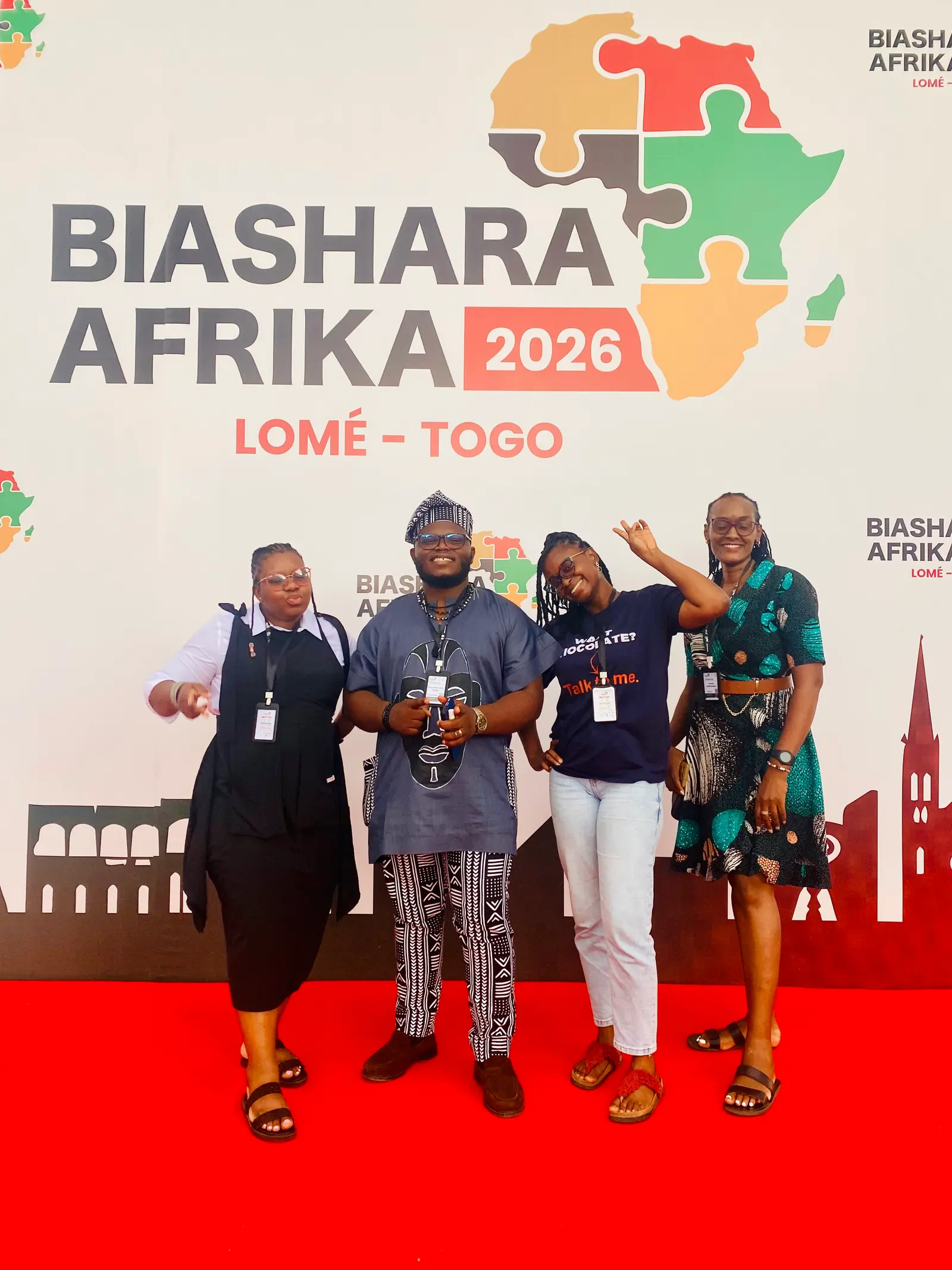 Four delegates in front of the Biashara Afrika 2026 backdrop in Lomé