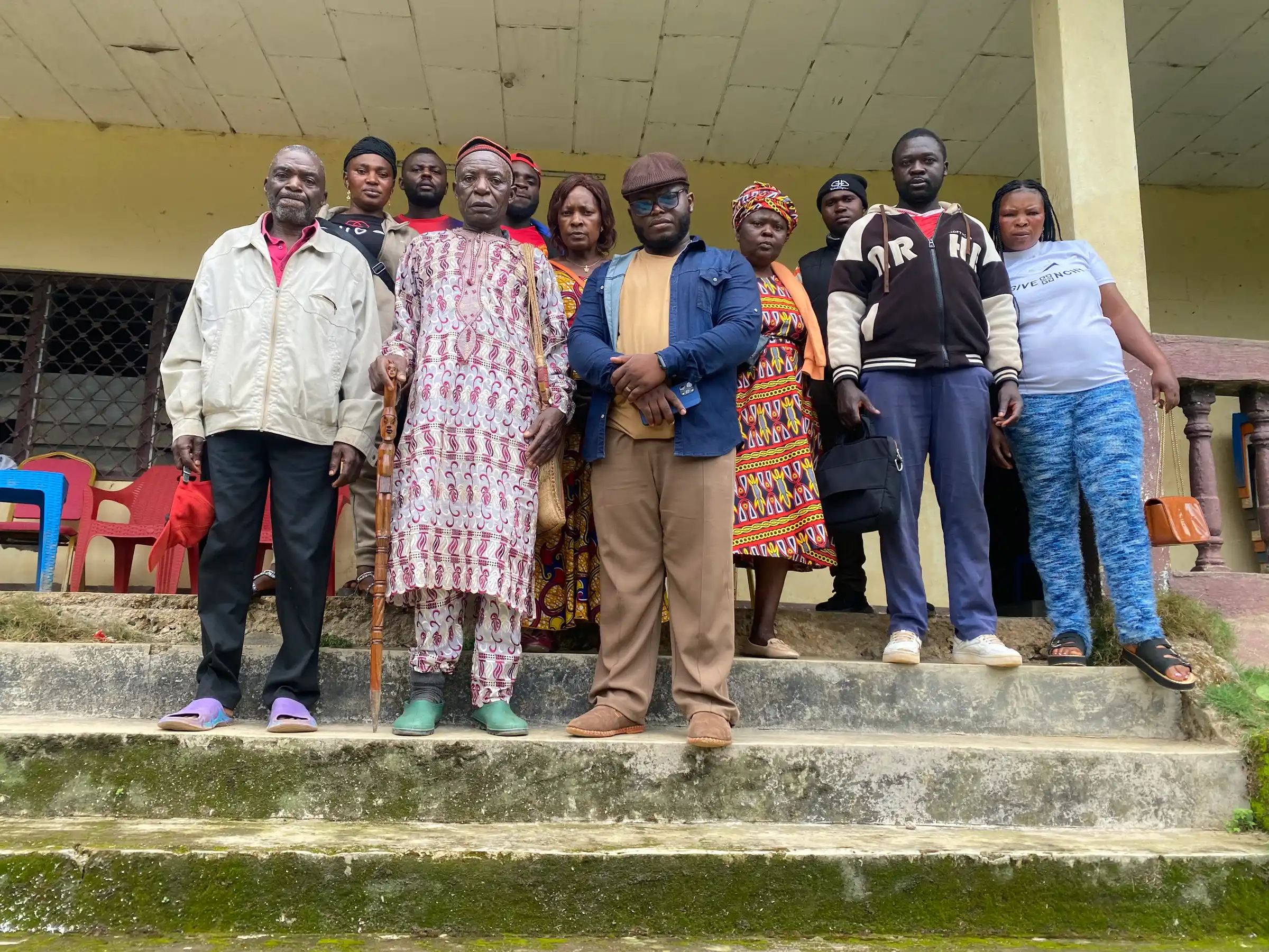 Farmers stand together on the steps of a building after a group meeting