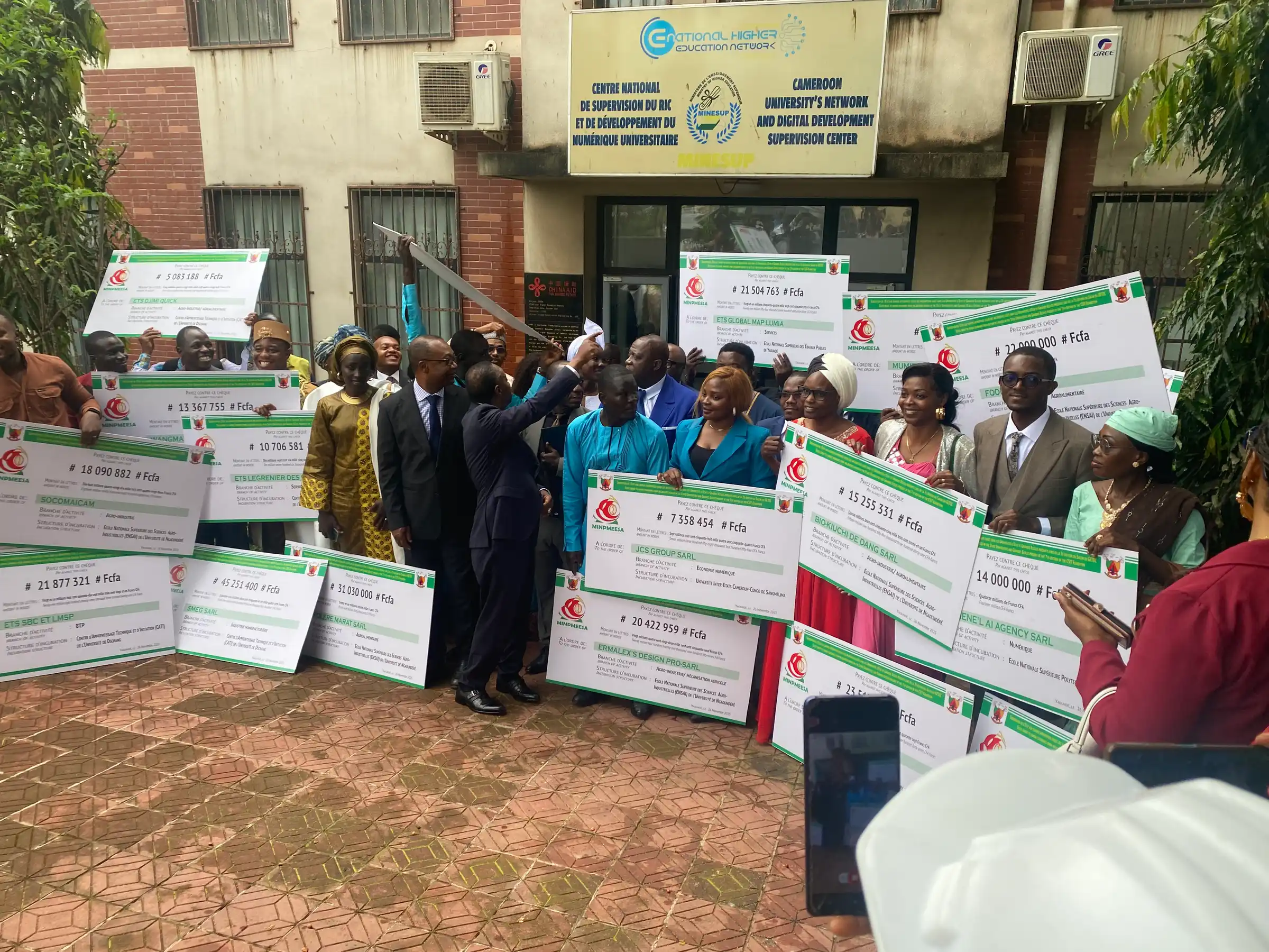 Grant recipients hold MINPMEESA cheques outside the MINESUP digital supervision centre