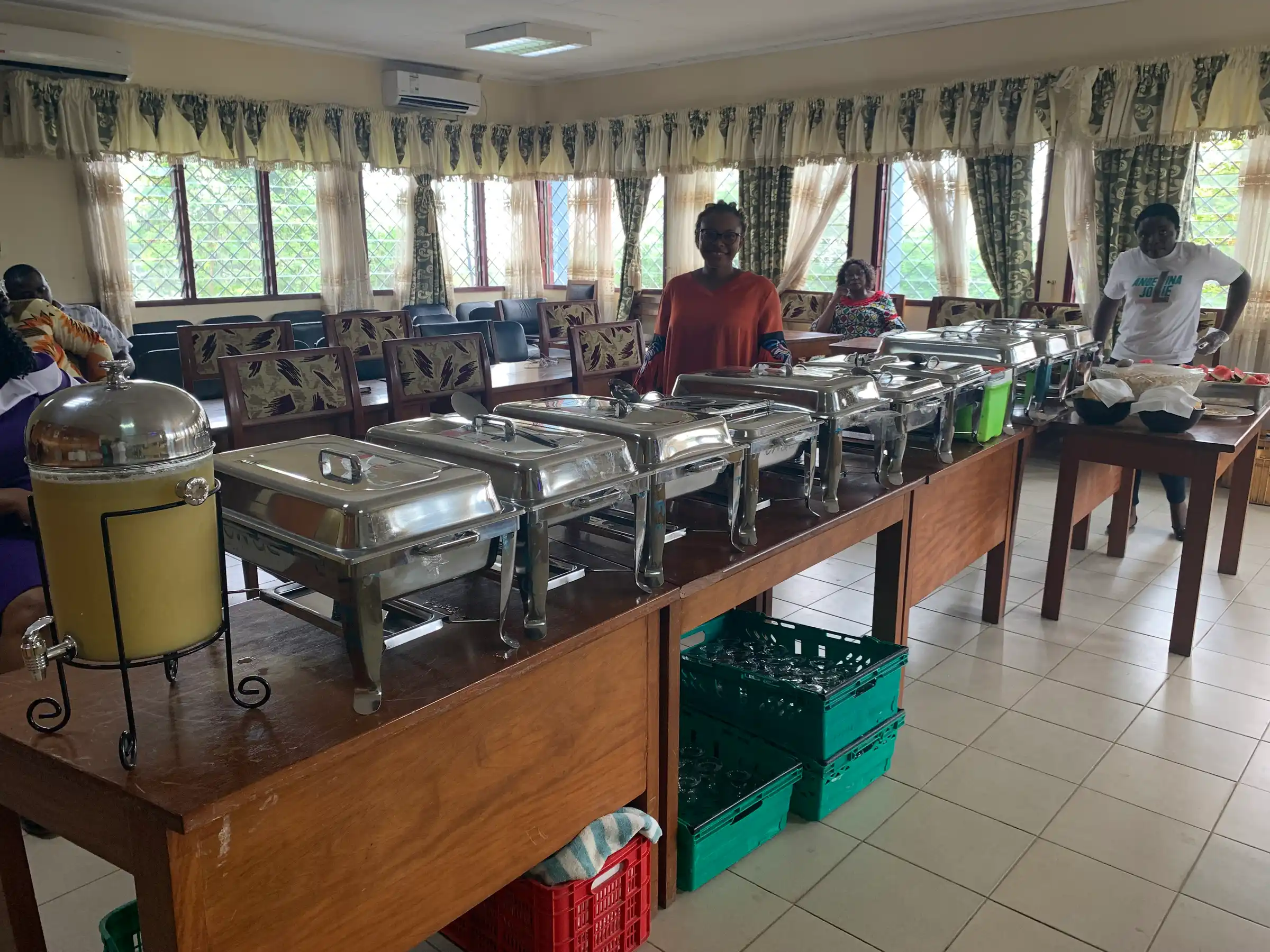 A Praïs catering buffet of chafing dishes laid out in a function hall