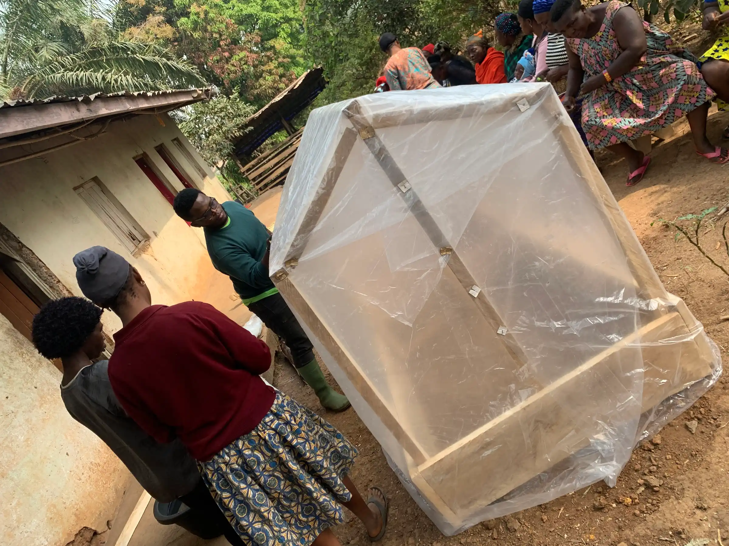 Participants lift a plastic-covered frame into place