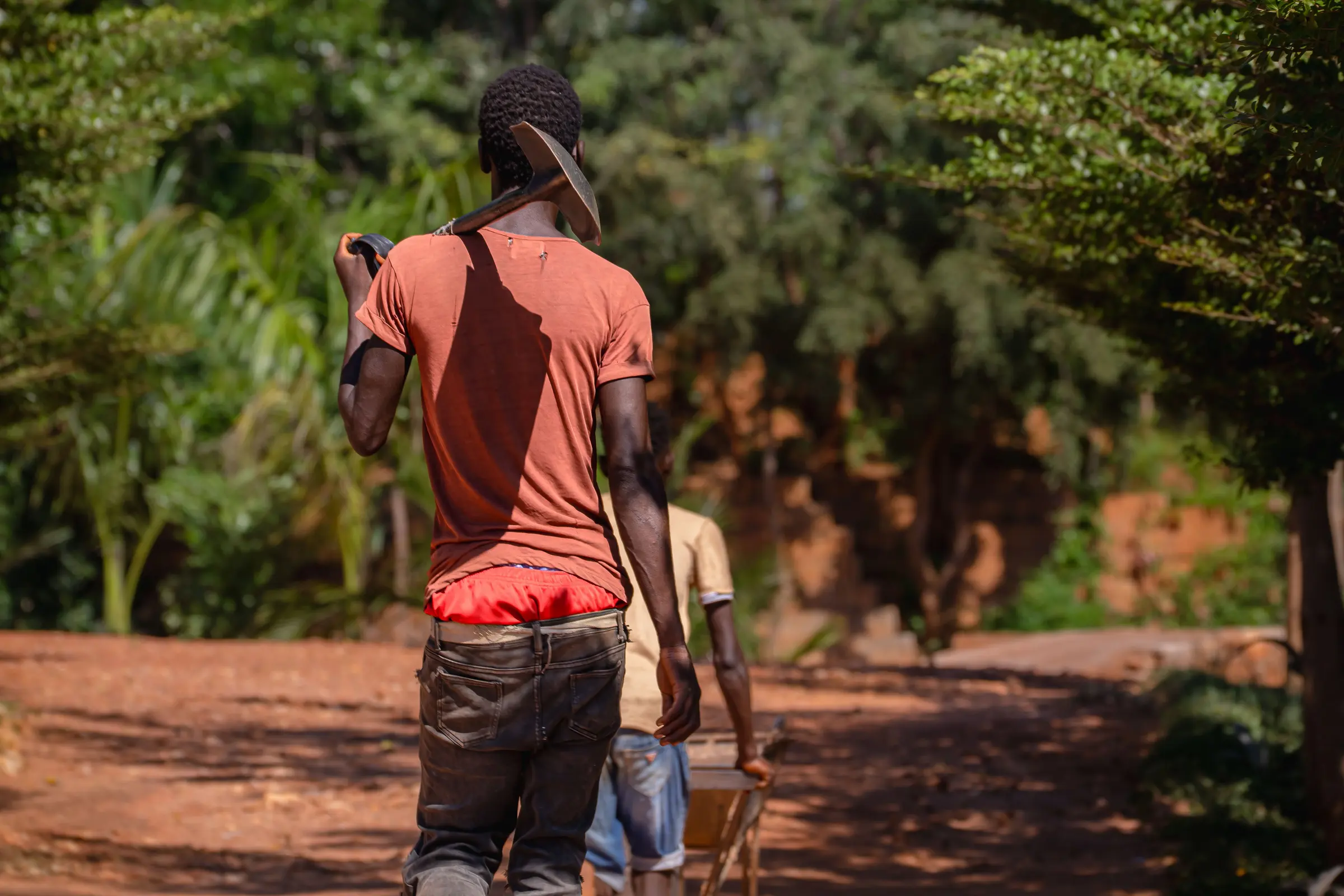 A farmer walking away down a rural path